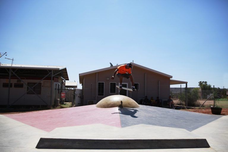 Aboriginal flag sun hipped bank at Ltyentye Apurte (Santa Teresa) Skatepark, Northern Territory